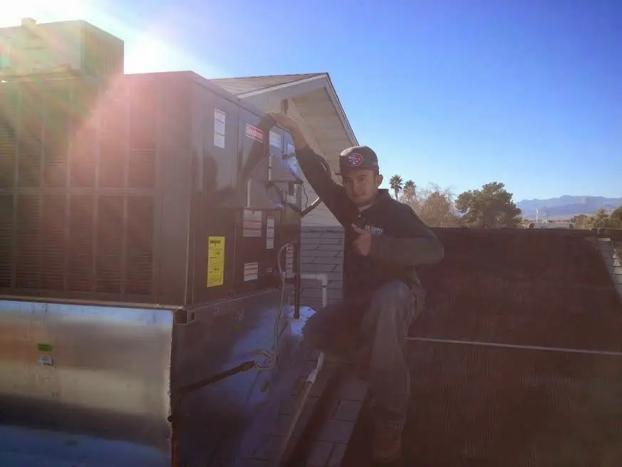 HVAC technician performing Air Duct Cleaning on a rooftop unit in Montgomery