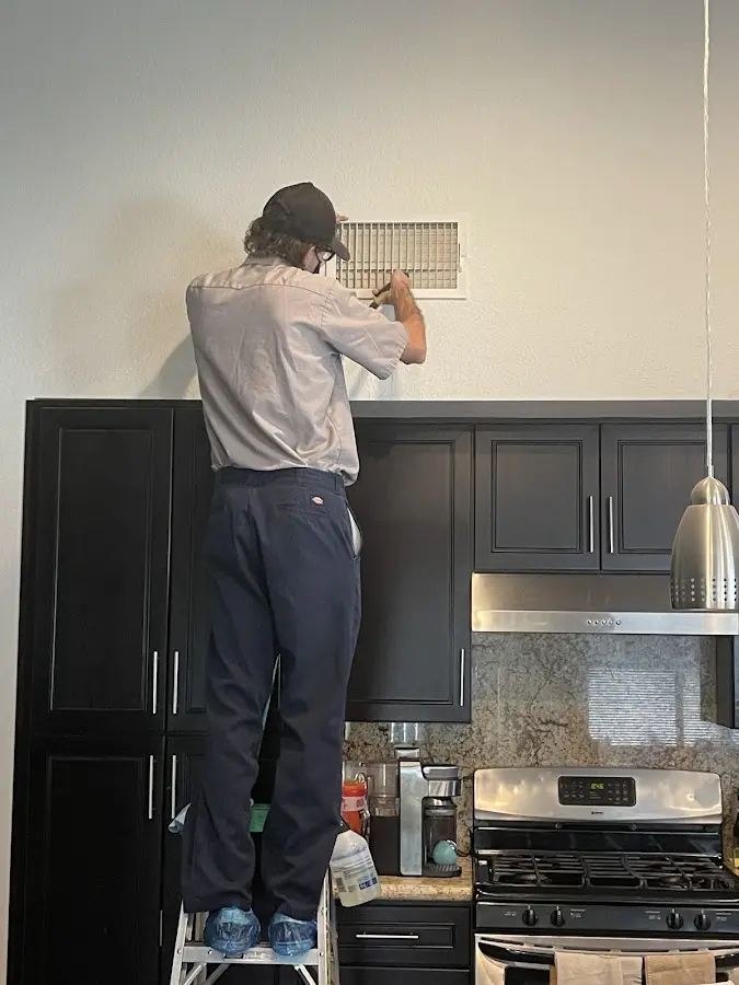Technician inspecting an air vent during HVAC service in Montgomery